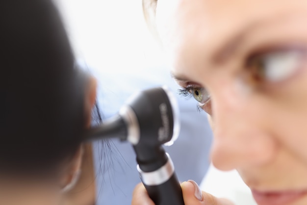 Um otorrinolaringologista examina o close up da orelha do paciente