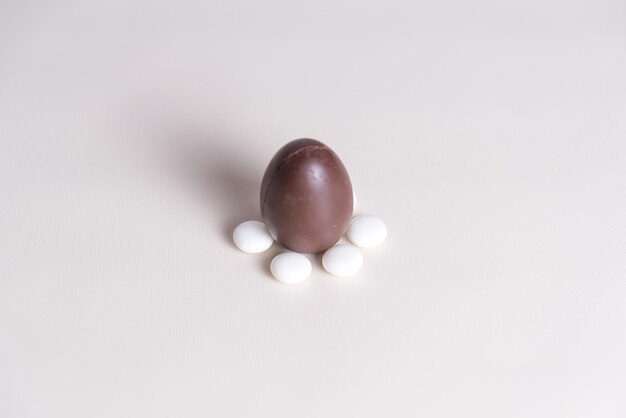 um ovo castanho com pílulas brancas em um fundo branco