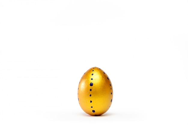 Foto um ovo da páscoa na moda colorido dourado no branco.