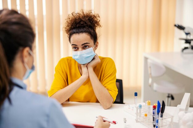 Foto um paciente doente está sentado no consultório do médico e conversando sobre problemas de saúde com um médico