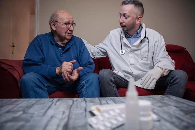 Um paciente idoso durante uma visita domiciliar está conversando com seus medicamentos de clínica geral na mesa