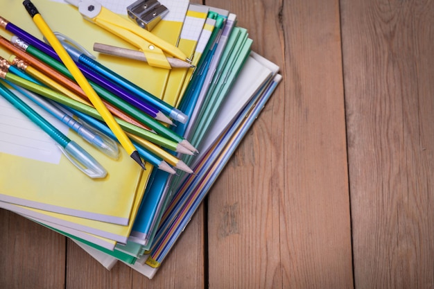 Um pacote de cadernos para a escola está sobre a velha mesa de madeira