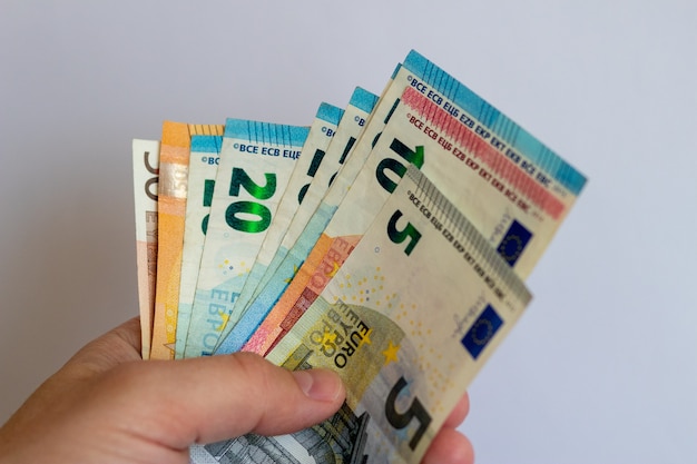 Um pacote de euros nas mãos sobre um fundo branco notas de euro em um fundo branco