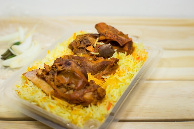 Um pacote plástico de arroz mandy de cordeiro em fundo de madeira A melhor comida árabe Foco seletivo