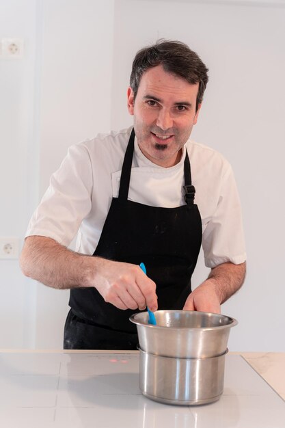 Um padeiro cozinhando um bolo de veludo vermelho em casa cozinhando em um trabalho de bainmarie em casa