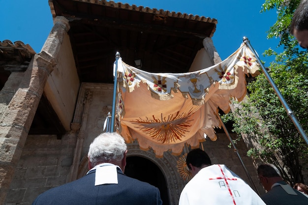 Foto um padre carrega a monstrança sob o dossel na procissão do corpo de cristo, espanha