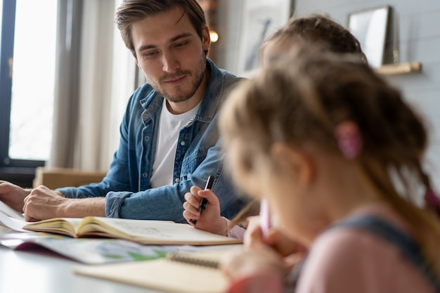 Um pai ajudando sua filha a fazer o dever de casa para a escola.