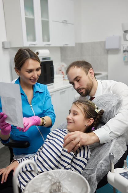 Um pai e uma filha vêm ao consultório odontológico para um exame