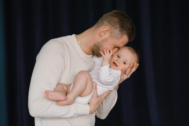 Um pai segura seu bebê recém-nascido em seus braços Papai beija seu filho pequeno