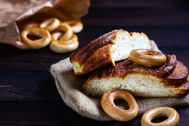 Um pão e um bagel em um balcão de padaria de madeira escura