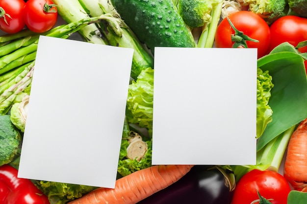 Um papel branco nítido em meio a uma série de legumes frescos ilustrando uma tapeçaria vibrante de naturezas