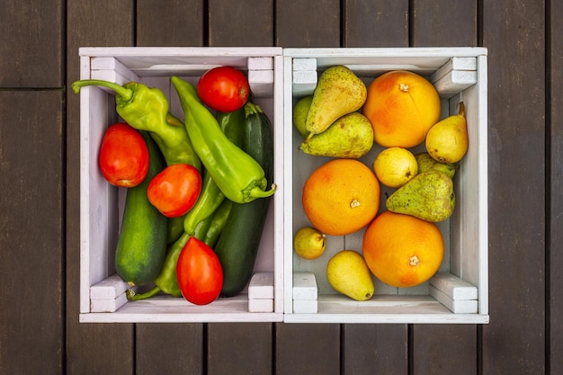 Um par de caixas de madeira cheias de frutas e vegetais frescos