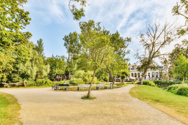 Um parque com bancos e uma casa ao fundo