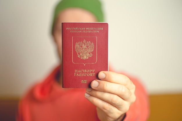 Um passaporte internacional estrangeiro russo nas mãos de um jovem cidadão russo.