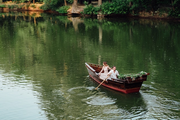 Um passeio de barco para um rapaz e uma rapariga ao longo dos canais e baías do rio repleto de salgueiros selvagens