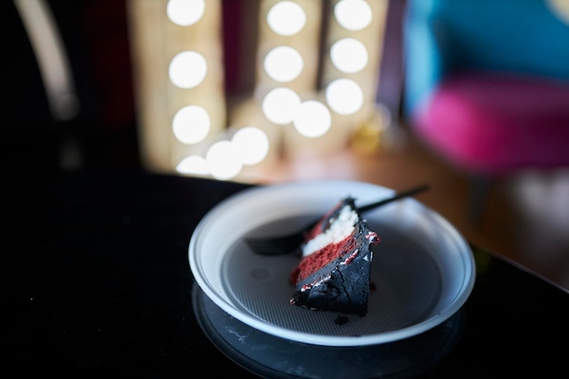 Um pedaço de bolo de aniversário em um prato de plástico branco