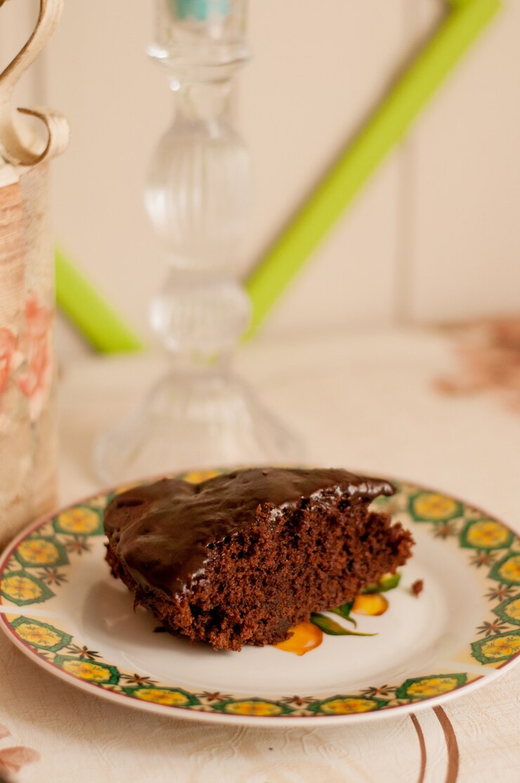 Foto um pedaço de bolo de chocolate com chocolate por cima em um prato aberto