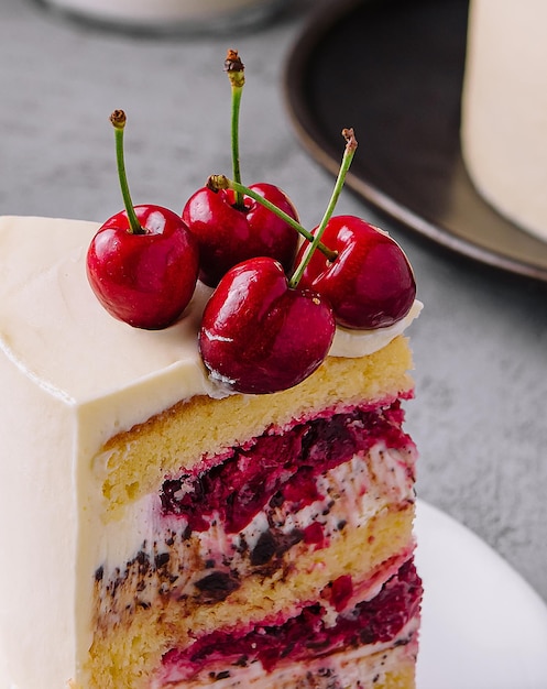 Foto um pedaço de bolo de leite com cerejas fecha