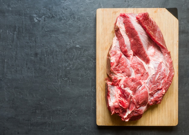 Um pedaço de carne vermelha carne crua na tábua de madeira