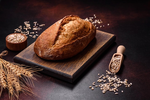 Um pedaço de pão integral com grãos de cereais em uma tábua de madeira
