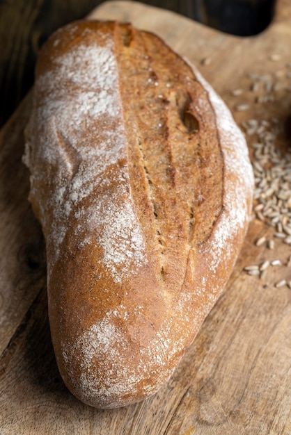 Um pedaço inteiro de pão escuro recém-assado um pedaço de pão fresco e macio feito de farinha de centeio com fermento