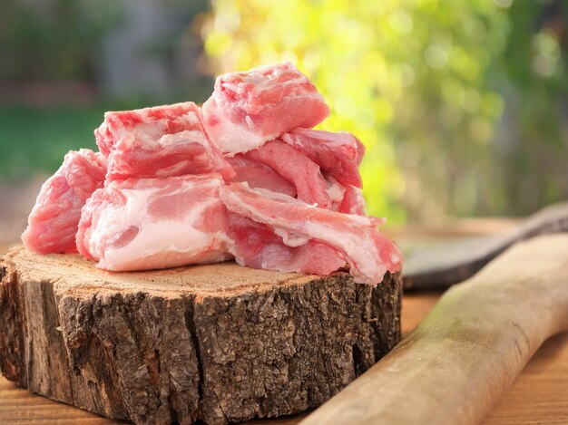 Um pedaços de carne de porco fresca com bacon em uma serra redonda, corte de uma árvore