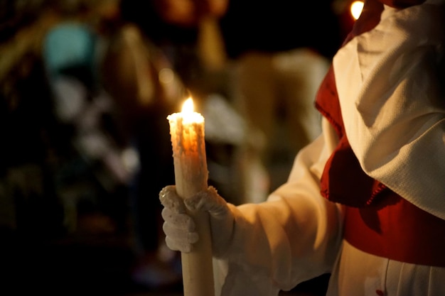 Foto um penitente com a sua vela na noite santa