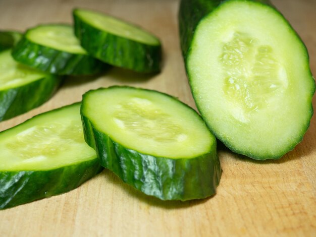 Um pepino liso de tamanho médio cortado em fatias Pepino em uma tábua Isolado de vegetais Vegetal fresco maduro