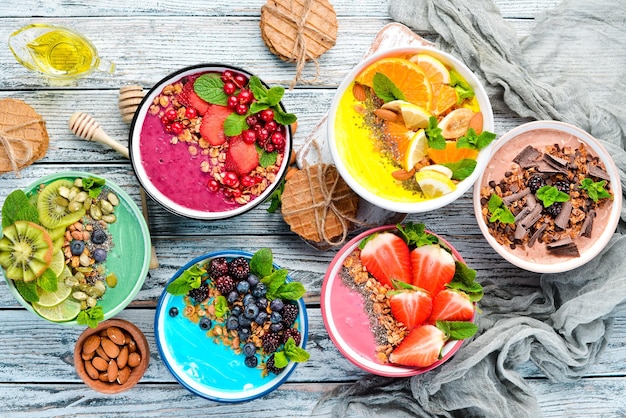 Um pequeno-almoço saudável batidos de frutas coloridas com iogurte, frutas frescas e bagas vista superior espaço livre para o seu texto em um fundo branco