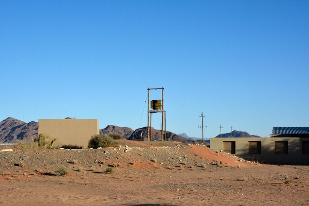 Um pequeno assentamento com uma torre de água e edifícios de colonos sob um céu claro