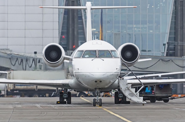 Um pequeno avião de passageiros estacionado em frente ao edifício do terminal do aeroporto