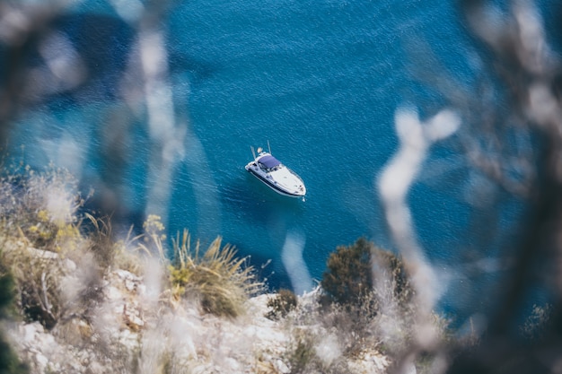 Foto um pequeno barco navegando perto da costa.