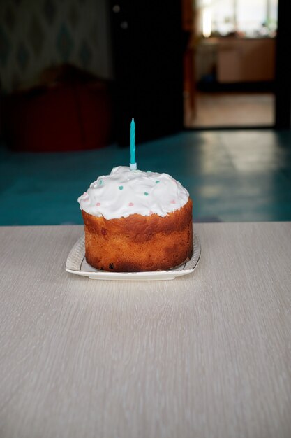 Um pequeno bolo festivo na mesa de aniversário