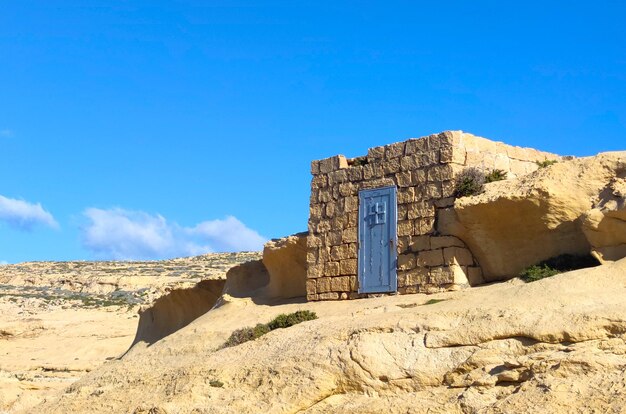 Foto um pequeno edifício de pedra com uma porta no topo