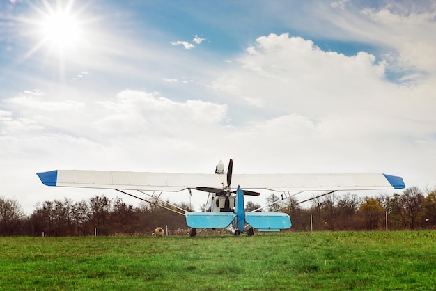 um pequeno filhote de spitz fofo ao lado de uma aeronave de luz branca no gramado