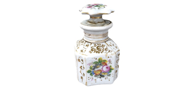 Um pequeno frasco de perfume com um desenho floral no topo.