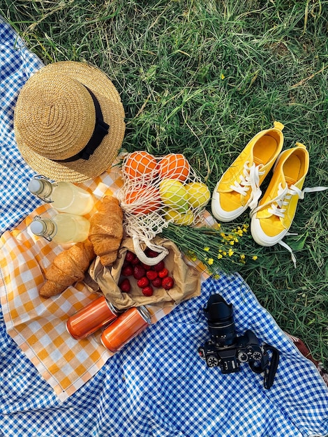 Um pequeno piquenique com croissants morangos e limonada em um cobertor xadrez azul