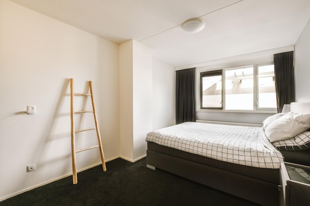 Foto um pequeno quarto com uma cama e uma escada em