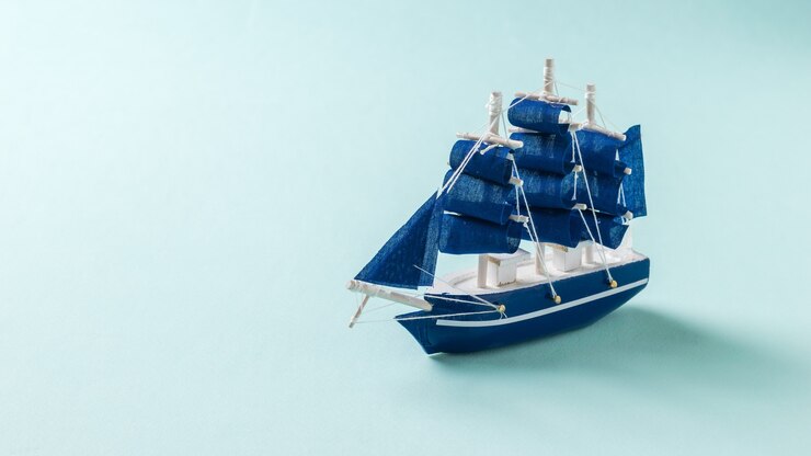 Foto um pequeno veleiro de brinquedo em um fundo azul claro. o conceito de viagem e aventura.