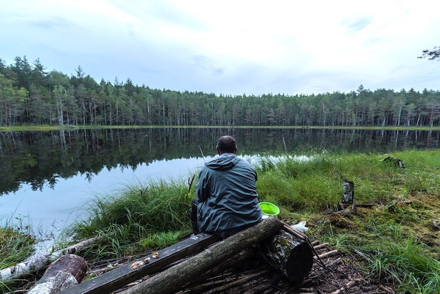 Um pescador está pescando em um lago da floresta