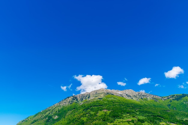 Um pico de montanha pitoresco contra um céu azul com nuvens brancas