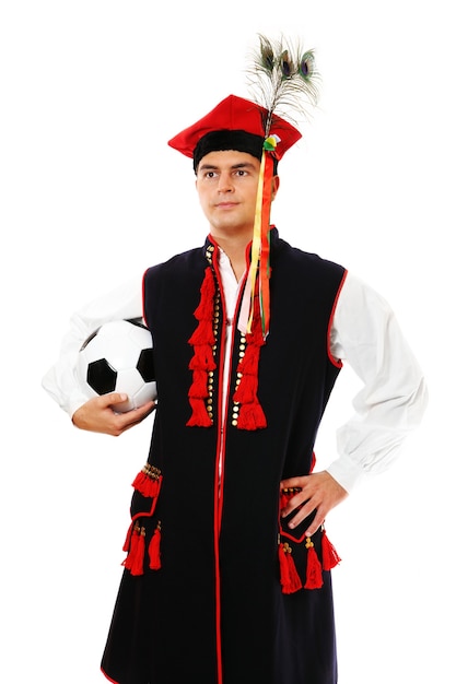 um polonês em uma roupa tradicional com uma bola de futebol