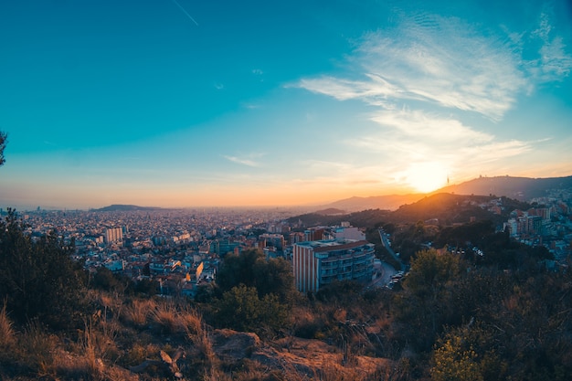 Um pôr do sol na montanha com a cidade de barcelona