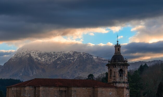 Foto um por do sol nublado sobre a montanha de anboto, país basco.