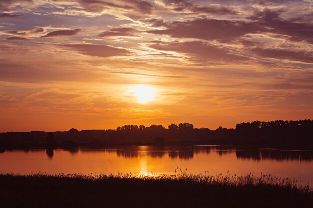 Um pôr do sol pitoresco no lago com belos destaques do sol na água