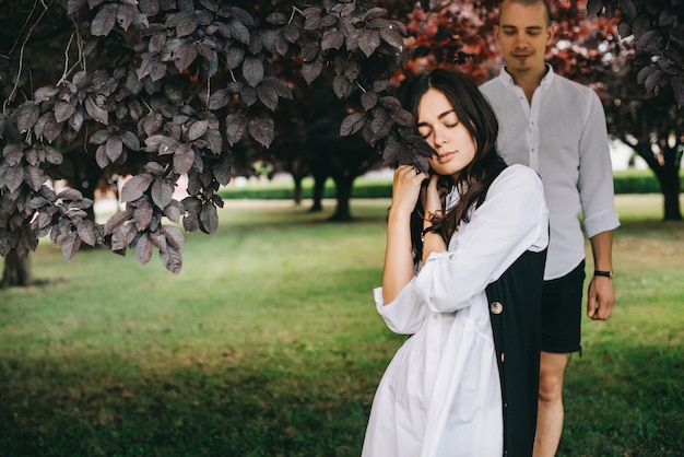 Foto um porttret de um jovem casal caucasiano elegante andando no belo parque