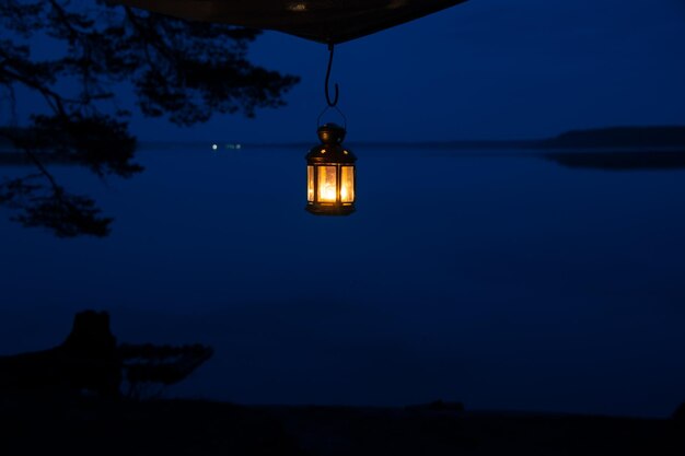 Foto um poste de lâmpada iluminado no lago contra o céu à noite