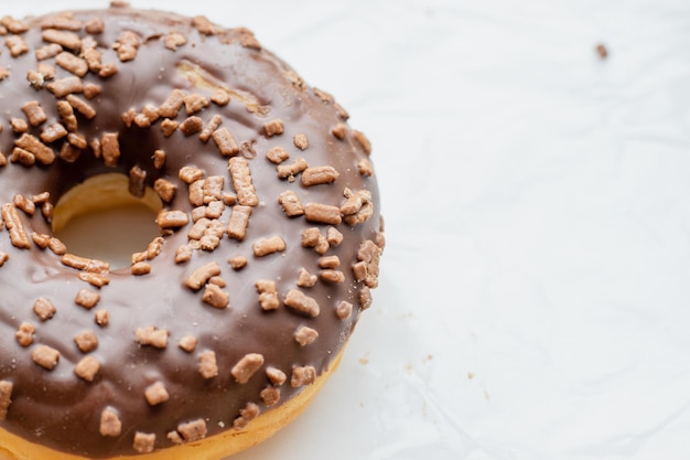 um pouco de donut com cobertura de chocolate em papel manteiga deliciosa sobremesa saborosa com partículas de chocolate por cima