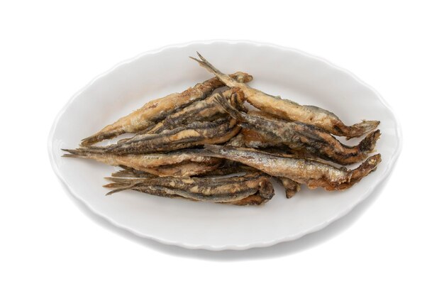 Um prato branco com anchovas fritas, isolado no fundo branco. Conceito de comida espanhola.