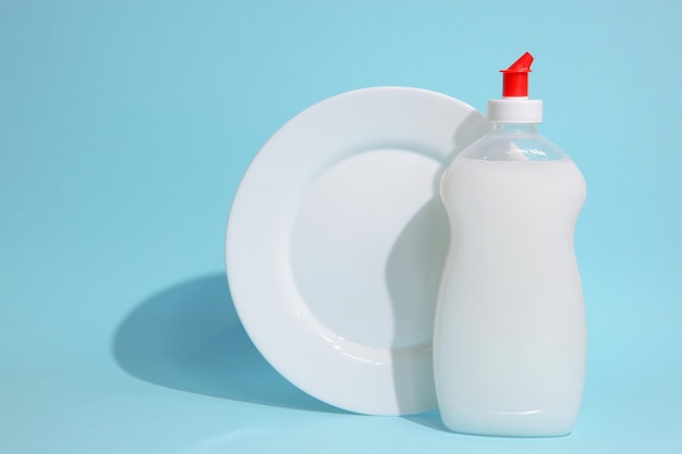 Um prato branco com tampa vermelha e um frasco de detergente.
